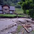 Apa învolburată a distrus podeţe şi porţiuni de drumuri comunale, lăsând zeci de case izolate